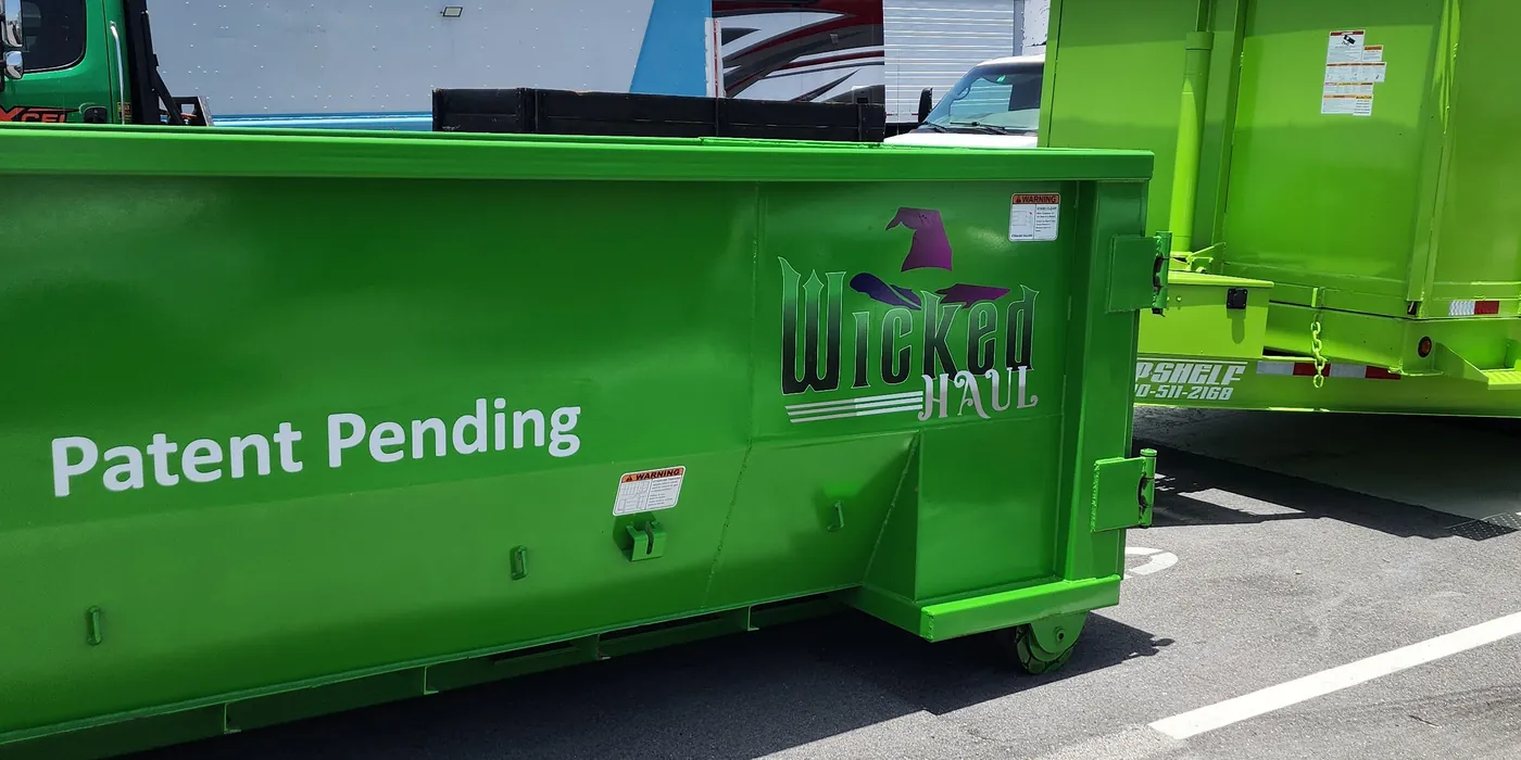 Side view of a Wicked Haul dumpster showing the front caster wheel and the Patent Pending marking