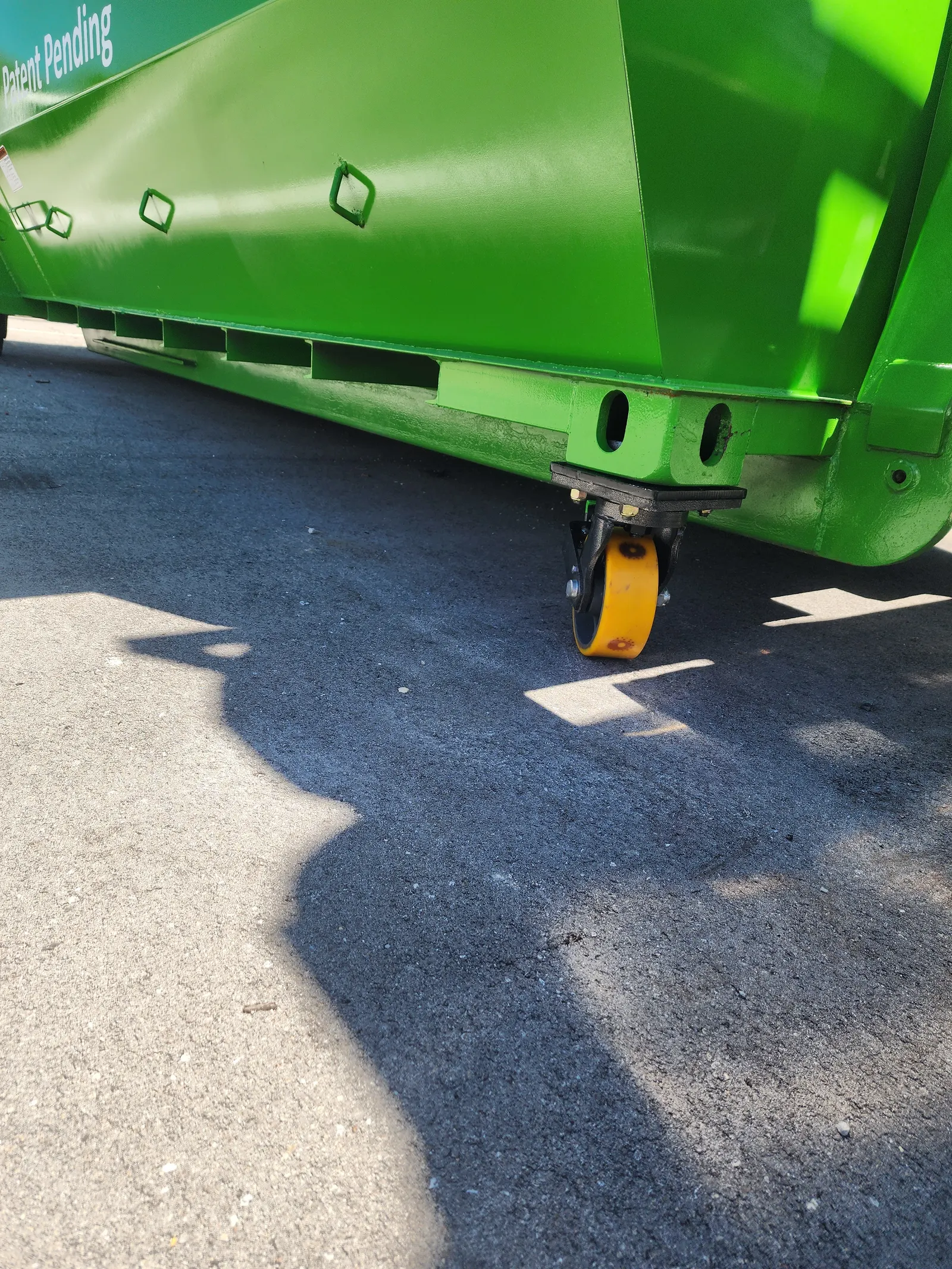 Rubberized front caster supporting the wheeled dumpster