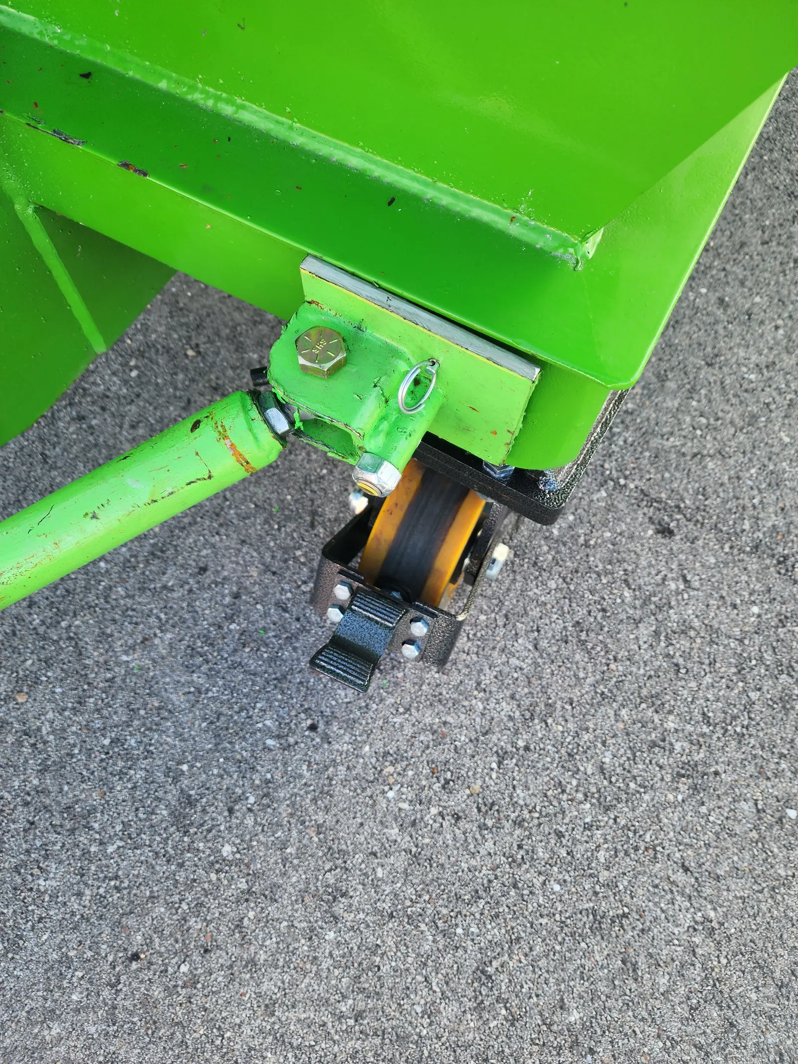 Close view of the wheeled dumpster corner and front caster assembly